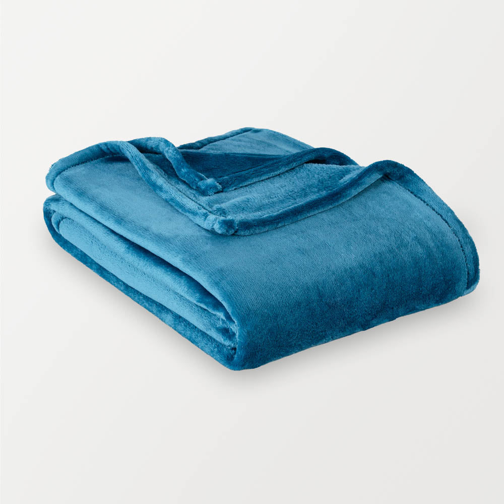 Folded blue blanket on a light gray background