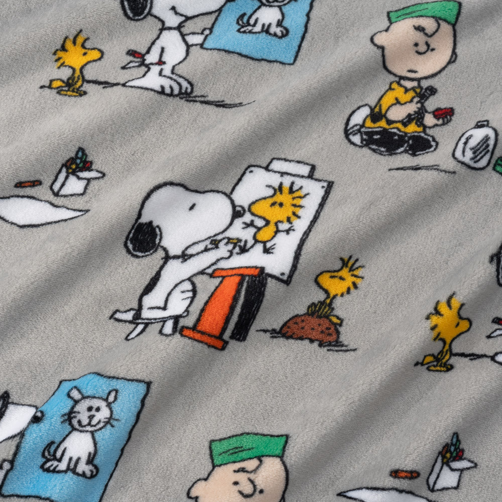Close up of a grey peanuts art class throw