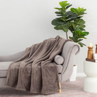 A grey PrimaLush Throw draped neatly over a grey chair.