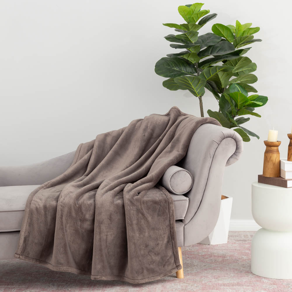 A grey PrimaLush Throw draped neatly over a grey chair.