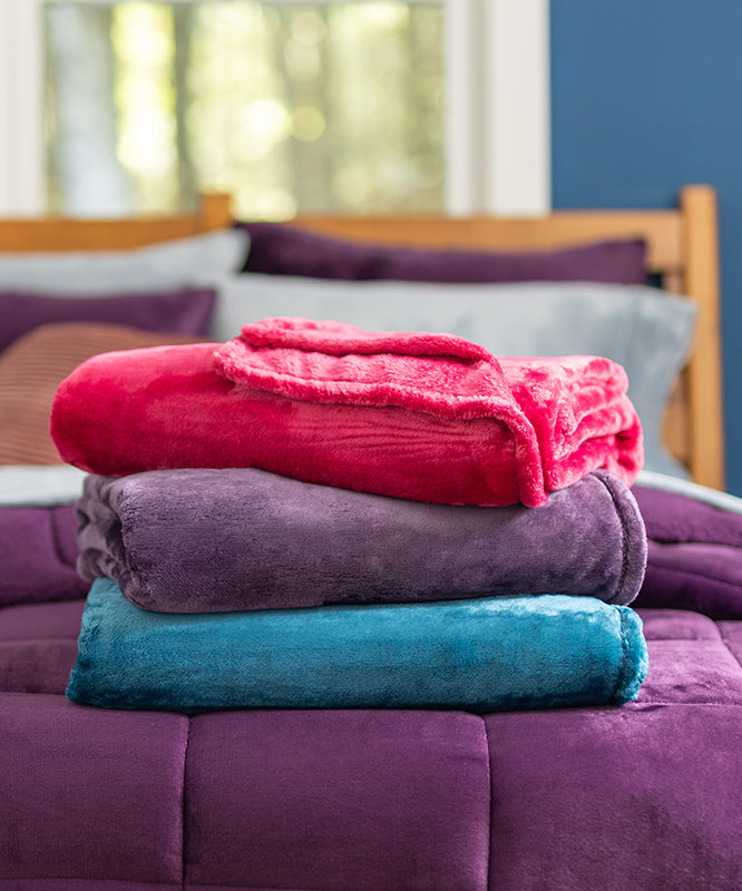 3 stack of the Hidden Gem blanket in blue, purple and a pinkish/red color