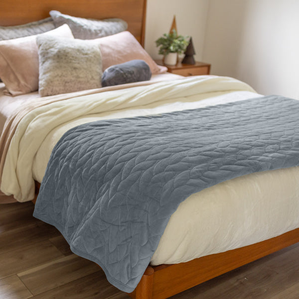 VelvetLoft® Quilt Set in Polar Blue on a bed with layered pillows, angled view