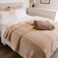 Beige blanket on a bed in a bedroom setting