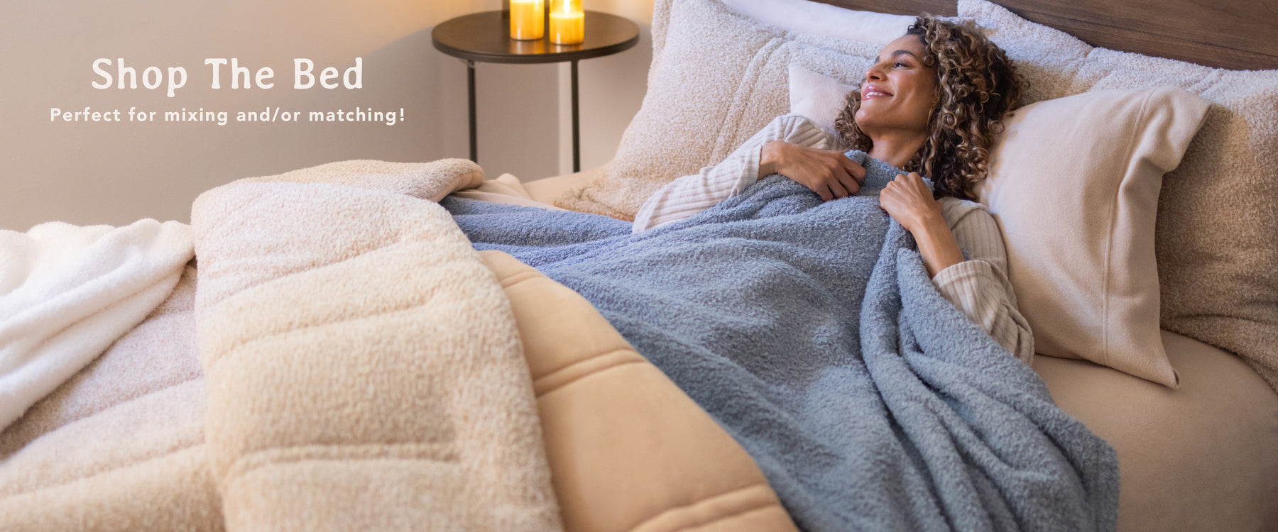 Shop The Bed: perfect for mixing and/or maching! Features a woman laying in a bed adorned with Retro Comfort Plush Bedding, Blankets, and Throws as she smiles.