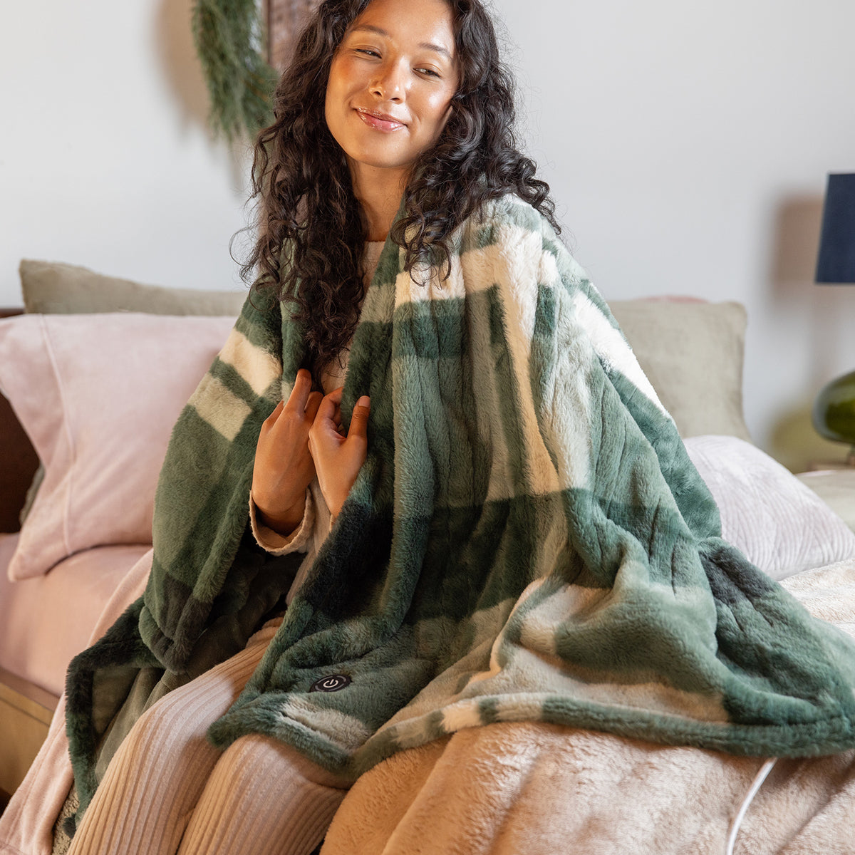 Female sitting is bed using the Sweet Retreat Blanket