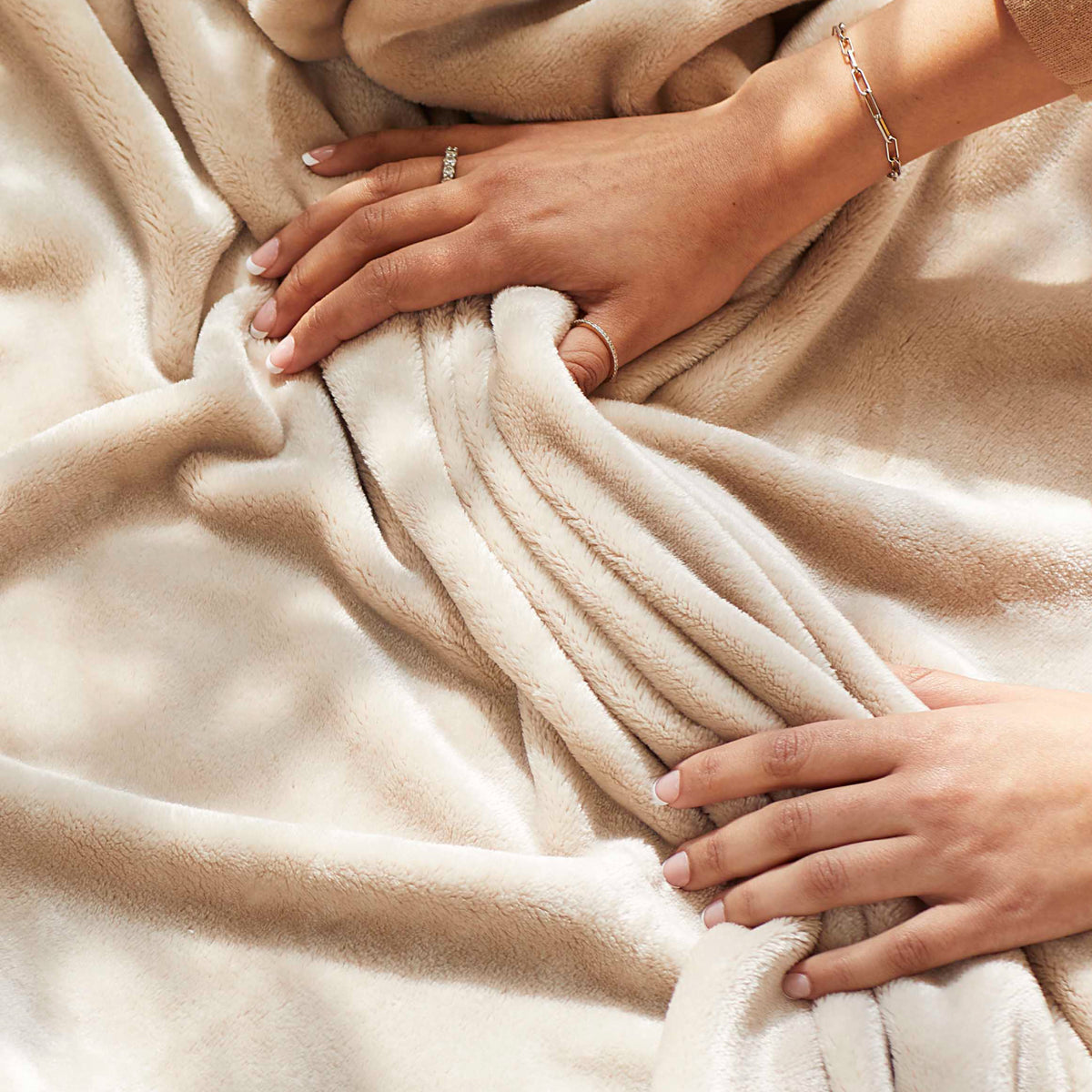 Image of a woman's hands caressing VelvetLoft in a neutral beige color. 