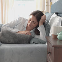 Ecothread Neckroll Pilliow video with a model laying on a bed