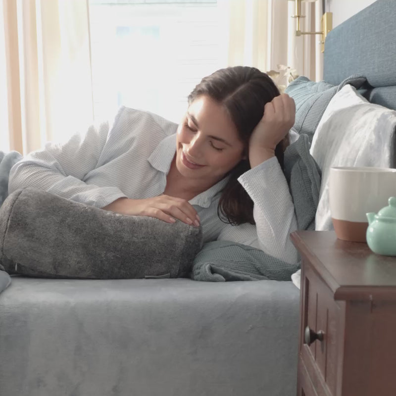 Ecothread Neckroll Pilliow video with a model laying on a bed