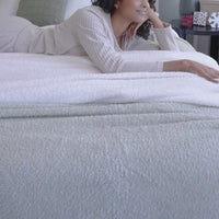 Video of a model laying on Retro Plush Blankets.